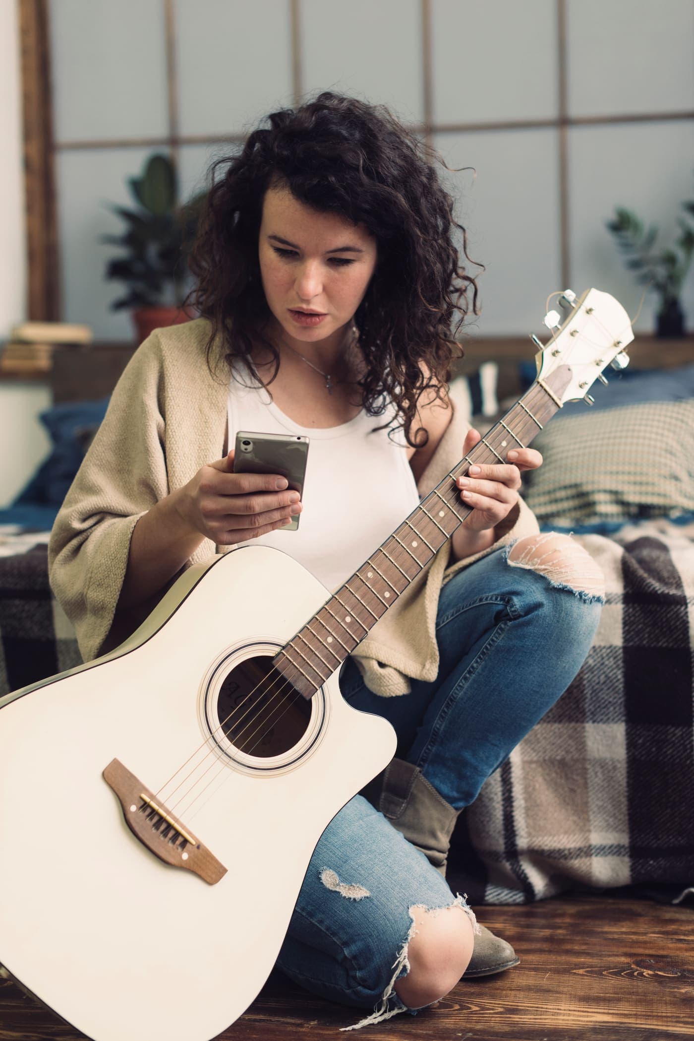 Profesora de guitarra revisando en el celular quién pagó la cuota